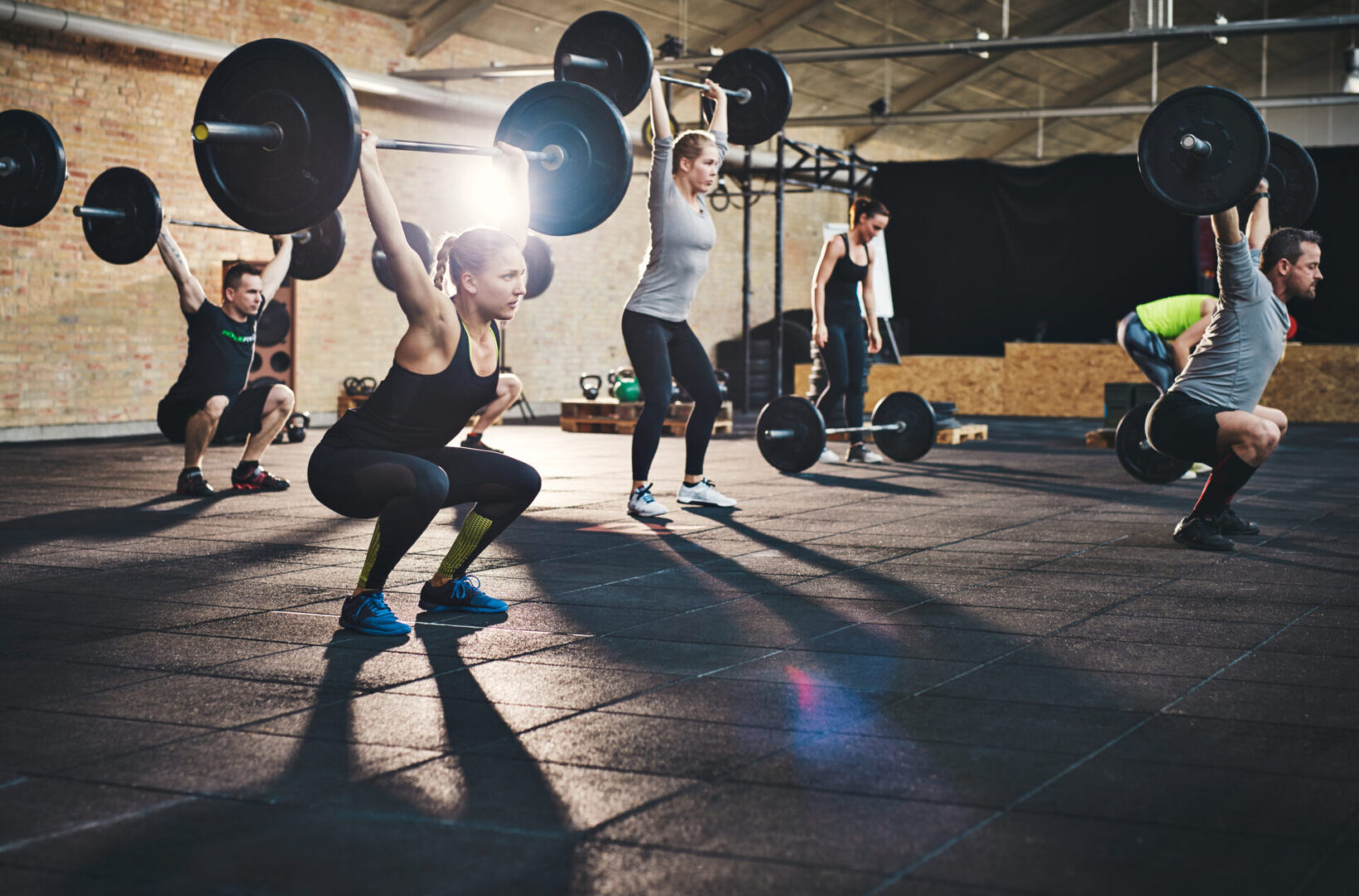 Fit,Young,People,Lifting,Barbells,Over,Their,Heads,Looking,Focused,